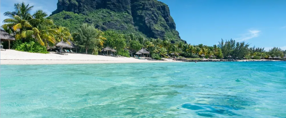 Der Strand von Le Morne mit Palmen, türkisfarbener Lagune und dem Berg Le Morne Brabant im Hintergrund